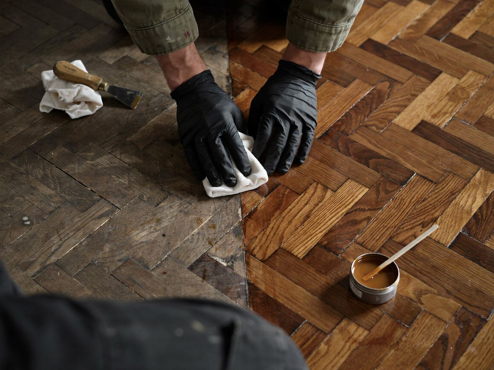 Old wooden floor being polished by hand, half restored